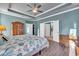 This primary bedroom features a wooden wardrobe, tray ceiling, and wood-look ceramic tile flooring at 1405 Osprey Pointe Ln., North Myrtle Beach, SC 29582