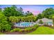 The neighborhood pool with a fence around it is surrounded by palm trees at 1405 Osprey Pointe Ln., North Myrtle Beach, SC 29582