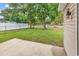 View of the home's side and backyard with lawn, concrete patio, and chain-link fence at 1900 Shell Ct., Surfside Beach, SC 29575