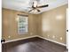 Cozy bedroom features hardwood floors, ceiling fan, and a bright window at 1900 Shell Ct., Surfside Beach, SC 29575