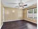 Spacious bedroom with dark wood-look floors, ceiling fan, and bright window at 1900 Shell Ct., Surfside Beach, SC 29575