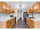 Galley kitchen with wood cabinets, modern appliances, and dark laminate flooring at 1900 Shell Ct., Surfside Beach, SC 29575