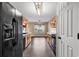 Galley-style kitchen with dark appliances and wooden cabinets overlooking the living room at 1900 Shell Ct., Surfside Beach, SC 29575