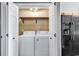 Bright laundry room featuring a washer and dryer, a shelf and white bi-fold doors at 1900 Shell Ct., Surfside Beach, SC 29575