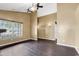 Open living room featuring dark hardwood floors, large window, and ceiling fans at 1900 Shell Ct., Surfside Beach, SC 29575