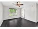 Spacious bedroom with dark hardwood flooring, ceiling fan, and ample natural light at 1900 Shell Ct., Surfside Beach, SC 29575