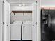 Convenient laundry area equipped with a washer, dryer, and wooden shelving at 1900 Shell Ct., Surfside Beach, SC 29575