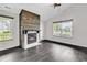 Bright living room with a fireplace, dark floors, and ample windows providing plenty of natural light at 1900 Shell Ct., Surfside Beach, SC 29575