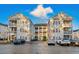 Inviting multi-story condo building showcases classic design with red shutters and ample parking space at 2060 Cross Gate Blvd. # 204, Surfside Beach, SC 29575