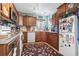 L-shaped kitchen with wood cabinets, granite counters, and white appliances at 2402 Hillside Dr. S, North Myrtle Beach, SC 29582