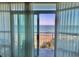 Breathtaking view of the ocean and beach from the private balcony, framed by sheer curtains at 2504 Ocean Blvd. N # 232, Myrtle Beach, SC 29577