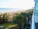 Great beach view from the balcony featuring palm trees, grassy area and lounge chairs at 2504 Ocean Blvd. N # 232, Myrtle Beach, SC 29577