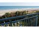 Amazing ocean view from the balcony overlooking a sandy beach with palm trees and lounge chairs at 2504 Ocean Blvd. N # 232, Myrtle Beach, SC 29577