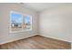 A bright bedroom showcasing a window with a view of the homes across the street and wood flooring at 391 Lifestyle Court, Surfside Beach, SC 29575