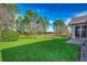 Lush backyard featuring green grass, bordered by mature trees, offers a serene outdoor setting at 4382 Saint Annes Ct., Myrtle Beach, SC 29579