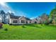 Rear view of the house with a big yard, neutral siding and multiple windows that offer views of the serene landscape at 4382 Saint Annes Ct., Myrtle Beach, SC 29579