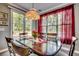 Cozy dining area with a garden view, a table set for four, and a stylish chandelier creating a warm atmosphere at 4382 Saint Annes Ct., Myrtle Beach, SC 29579