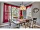 Bright dining area with a decorative chandelier, a table set for four, and views of the outdoor greenery at 4382 Saint Annes Ct., Myrtle Beach, SC 29579