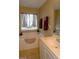 Bright bathroom featuring a bathtub, decorative window, and vanity with sink at 4657 Fringetree Dr. # C, Murrells Inlet, SC 29576