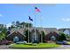 Clubhouse featuring manicured landscaping, multiple flag poles, and ample parking at 4657 Fringetree Dr. # C, Murrells Inlet, SC 29576