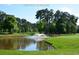 Picturesque pond with a fountain on a golf course, surrounded by lush trees at 4657 Fringetree Dr. # C, Murrells Inlet, SC 29576