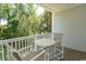 Balcony with two chairs and a small table, offering wooded views at 5801 Oyster Catcher Dr. # 1624, North Myrtle Beach, SC 29582