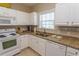 Well-equipped kitchen featuring white cabinets, granite countertops, and modern appliances at 5801 Oyster Catcher Dr. # 1624, North Myrtle Beach, SC 29582