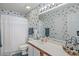Bathroom with vanity, mirror, white cabinets and floral wallpaper at 820 Fairway Dr. # 1605, Longs, SC 29568