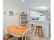 View of dining area with wood table, chairs, wicker shelf and kitchen at 820 Fairway Dr. # 1605, Longs, SC 29568