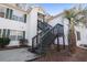 Exterior view of a two-story condo with a wooden staircase and mature landscaping at 820 Fairway Dr. # 1605, Longs, SC 29568