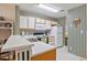 Functional kitchen with white cabinets, laminate countertops, and green and white striped wallpaper at 820 Fairway Dr. # 1605, Longs, SC 29568