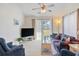 Bright living room featuring a ceiling fan, neutral carpet, and sliding glass doors to a patio at 820 Fairway Dr. # 1605, Longs, SC 29568