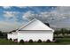Rear view of a white farmhouse with black roof and landscaping at 2184 Pettus Way, Surfside Beach, SC 29575