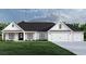 White farmhouse exterior with a black roof, two-car garage, and landscaping at 2180 Pettus Way, Surfside Beach, SC 29575