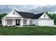 White farmhouse exterior with a black roof, two-car garage, and landscaping at 2180 Pettus Way, Surfside Beach, SC 29575