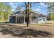 The back of the home showcases a screened porch and a spacious backyard with plenty of trees at 1033 Pisgah Church Rd., Aynor, SC 29511