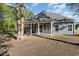 Rear exterior showcasing the screened-in porch with the grey siding of the home and mature trees at 1033 Pisgah Church Rd., Aynor, SC 29511