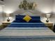 King-size bed with blue bedding and wall art at 1207 S Ocean Blvd. # 20207, Myrtle Beach, SC 29577