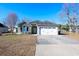 House exterior with green siding, white garage door and lawn at 130 Lions Paw Ct., Loris, SC 29569