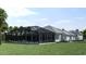 Exterior view of a screened-in pool area, back porch, well-manicured lawn, and neutral paint at 1526 Bellini Ct., Myrtle Beach, SC 29579
