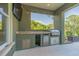This covered outdoor kitchen is equipped with a granite countertop, stainless steel grill, and mini-fridge at 2000 Hideaway Point, Myrtle Beach, SC 29579