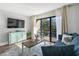Bright living room with balcony access, comfy seating, and a large TV at 210 75Th Ave N # 4011, Myrtle Beach, SC 29572