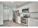 Modern kitchen with white cabinets, stainless steel appliances and marble countertops at 227 Birdie Way, Longs, SC 29568