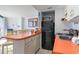 Compact kitchen with orange countertops, black appliances, and breakfast bar at 2310 North Ocean Blvd. # 605, Myrtle Beach, SC 29577