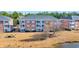 Aerial view of brick condo buildings overlooking a pond, dry grassy areas, and trees at 3923 Gladiola Ct. # 301, Myrtle Beach, SC 29588