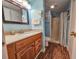Bathroom features a wood vanity with light countertops, a large mirror, and a walk-in shower at 410 Melrose Pl. # 219, Myrtle Beach, SC 29572