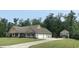 Exterior view of home with a wide driveway, multiple garage doors and an additional outbuilding at 640 Fox Hollow Rd., Murrells Inlet, SC 29576