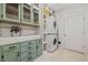 Well-organized laundry room with a utility sink, stacked washer/dryer, and custom cabinets at 640 Fox Hollow Rd., Murrells Inlet, SC 29576