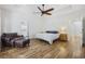 Bright main bedroom with wood floors, ceiling fan, and bathroom entrance at 640 Fox Hollow Rd., Murrells Inlet, SC 29576