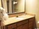 Bathroom with a granite countertop, well-lit mirror and wooden cabinets at 7100 N Ocean Blvd. # 1608, Myrtle Beach, SC 29572